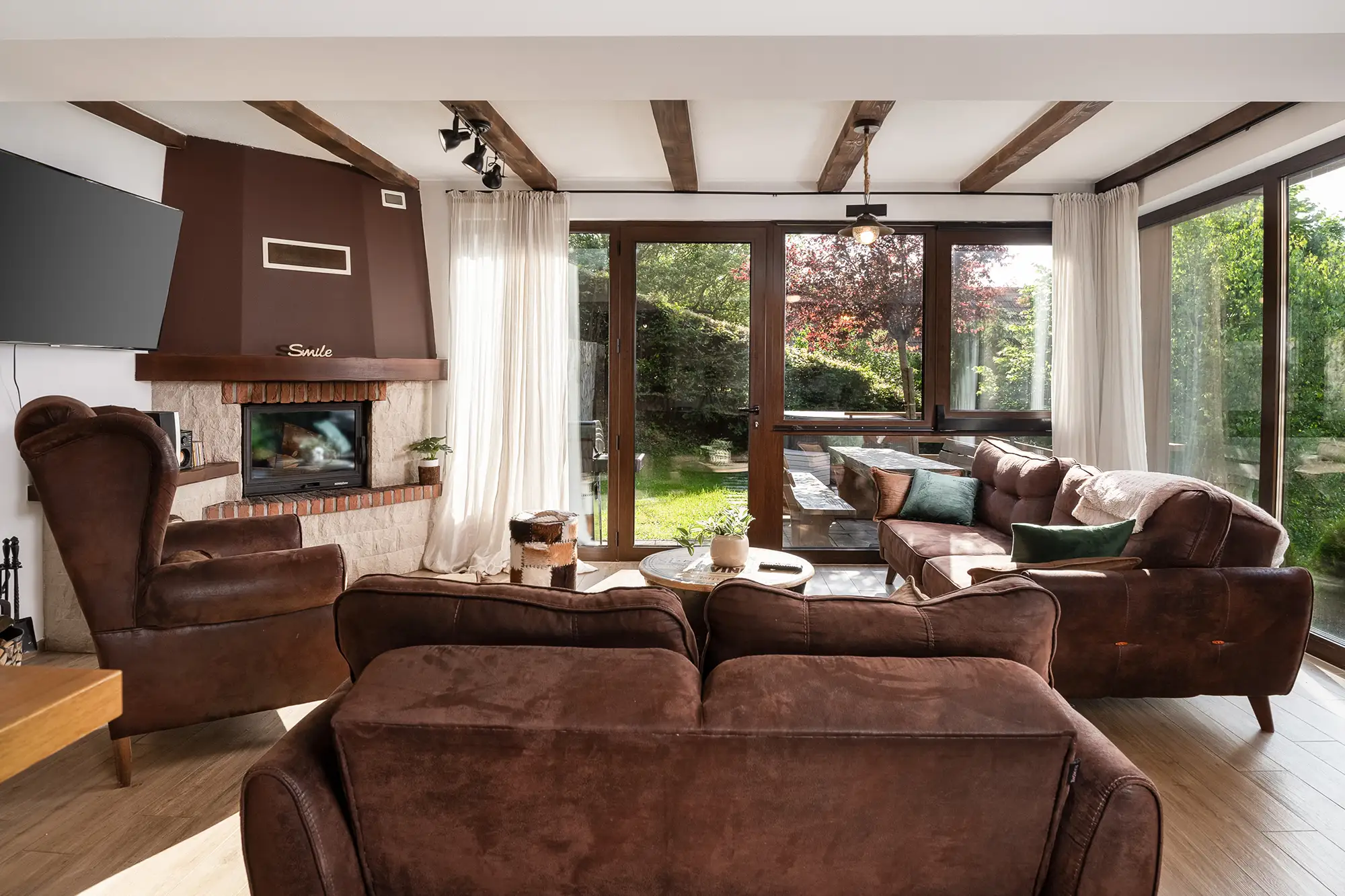 Dnevni boravak s kamenim kaminom, drvenim gredama i kožnim sofama