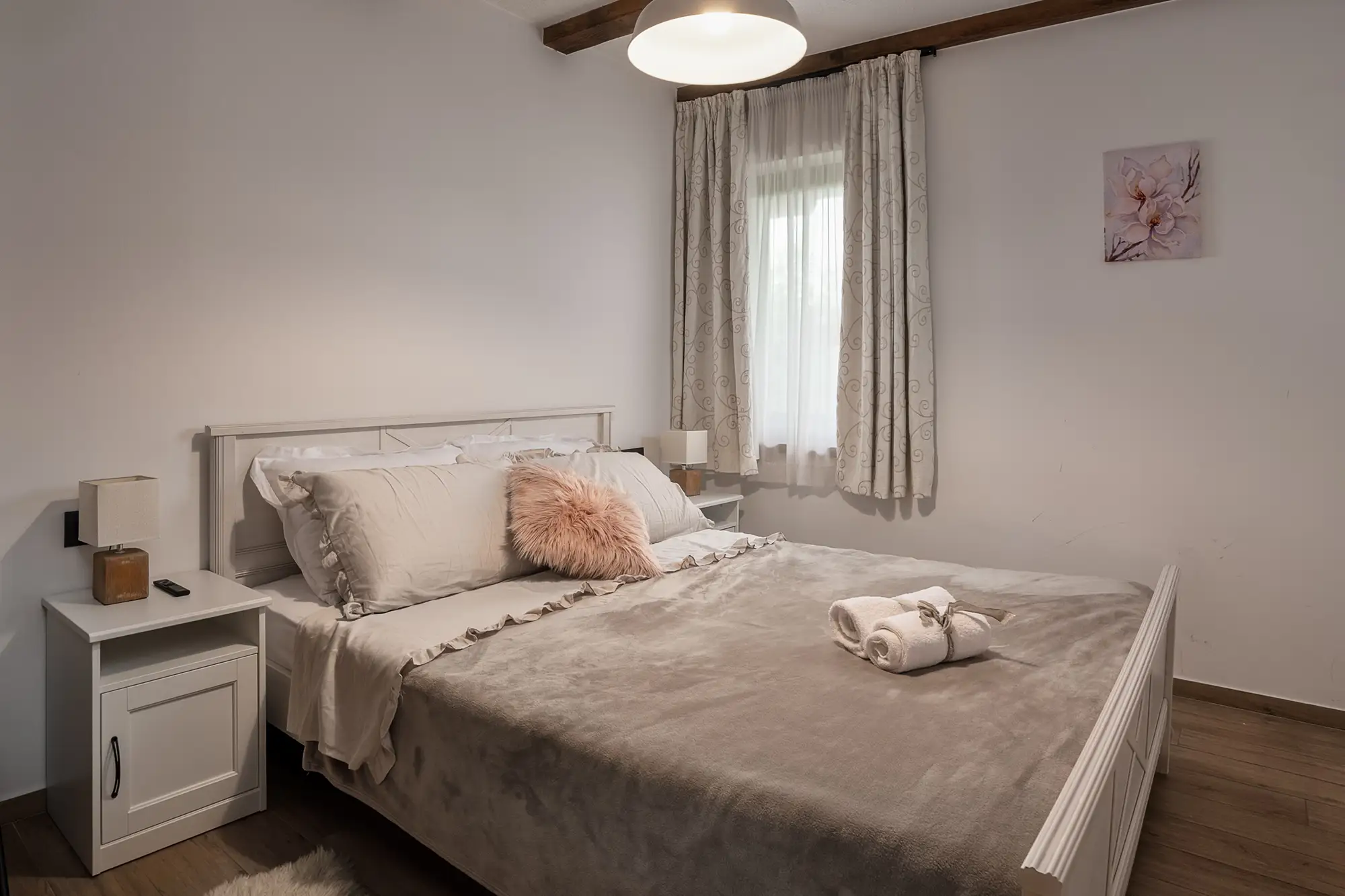 Spavaća soba u prizemlju s mekim neutralnim tonovima i cvjetnim umjetničkim djelom